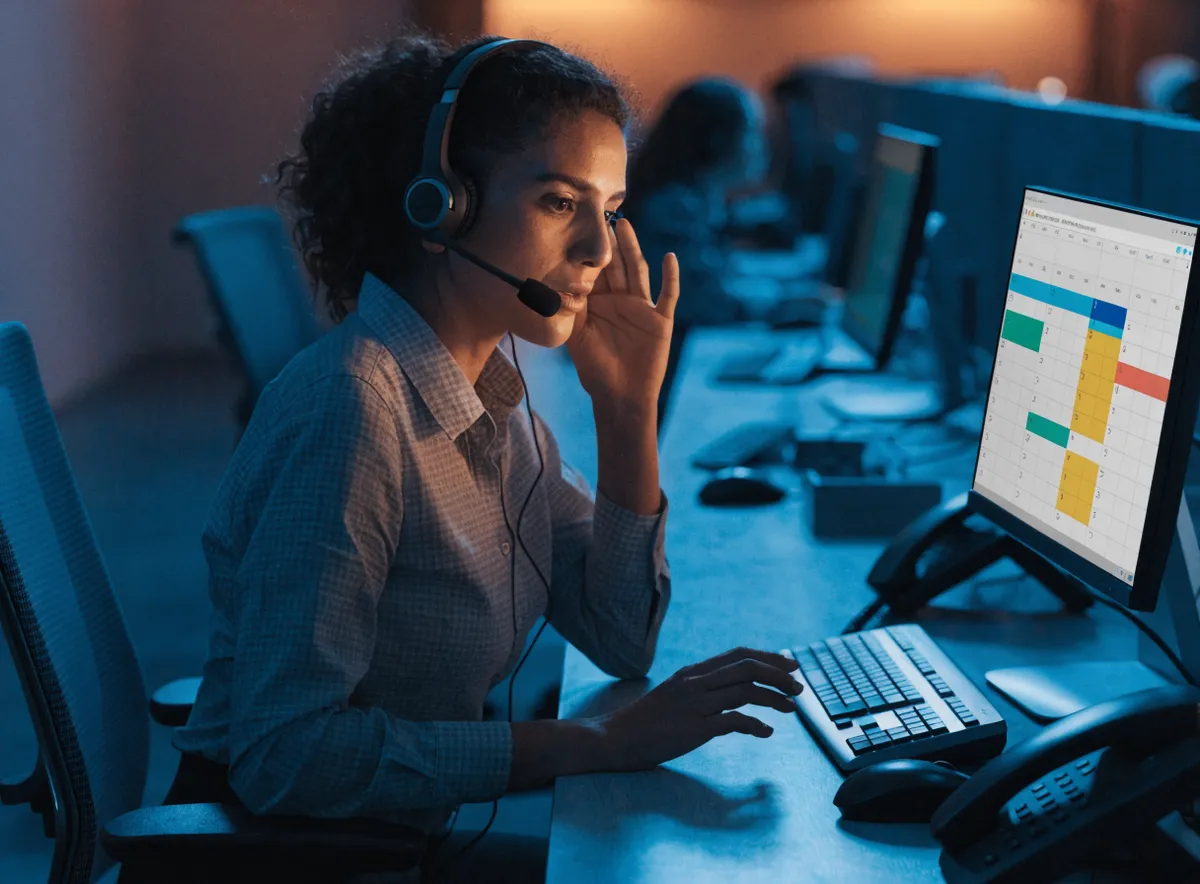 Agente de contact center gestionando una cita previa por teléfono mientras actualiza la agenda compartida en pantalla