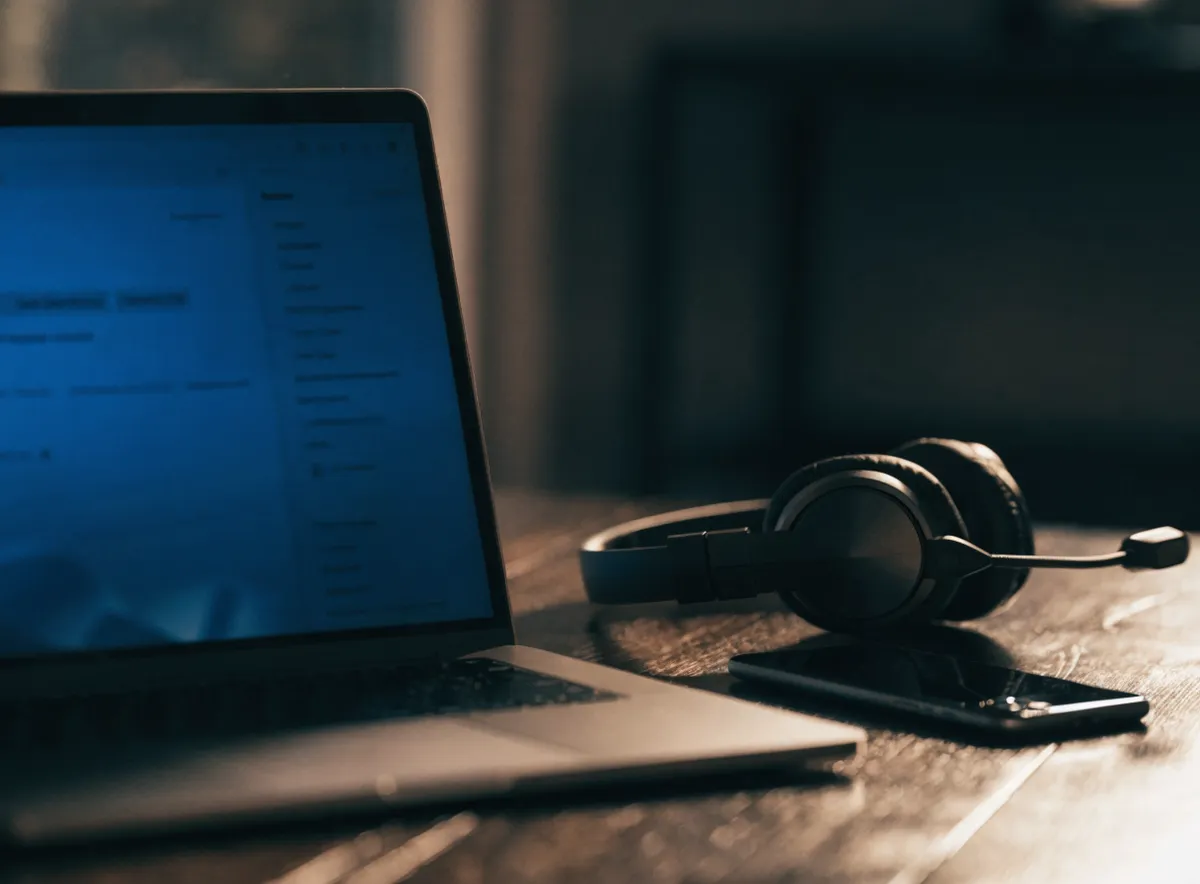 Escritorio de sales development para una empresa SaaS con portátil y auriculares